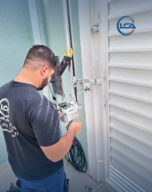 Técnico da LCA ajustando a placa de um motor de portão de pedestre